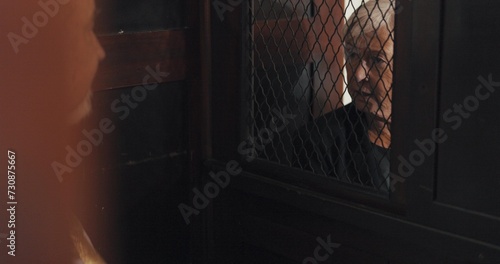 Fototapeta Priest, talking and listening in confession booth with senior woman, sinner or secret for forgiveness in church