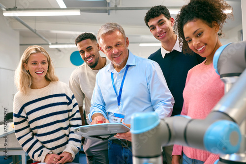 Group Of College Or University Engineering Students In Robotics Class With Male Teacher