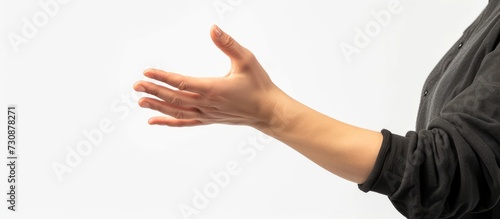 The person extends their arm, making a gesture with their hand, and offers it for a handshake. photo