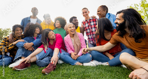 diverse groups of multicultural friends spending time together on the campus lawn laughing