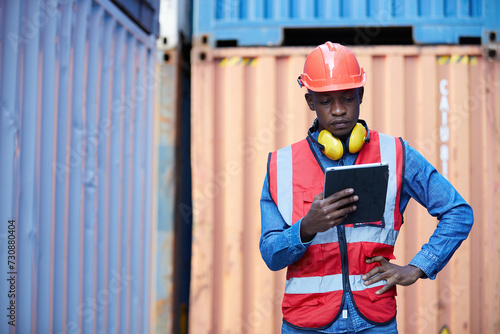 factory worker or engineer working on tablet in containers warehouse storage