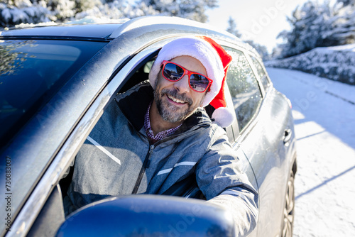Happy man with santa hat on driver seat. Winter vacation and holidays concept.