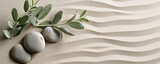 Smooth pebbles and sprigs of greenery arranged artistically on raked sand, creating a tranquil Zen garden pattern.	
