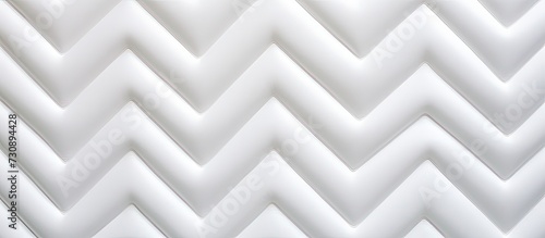 White zigzag pattern on quilted surface, creating an abstract background with a soft texture. © Vusal