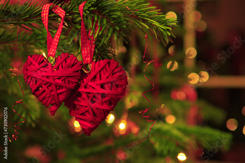 Valentine's Day background with two hanging heart shapes on Christmas tree.