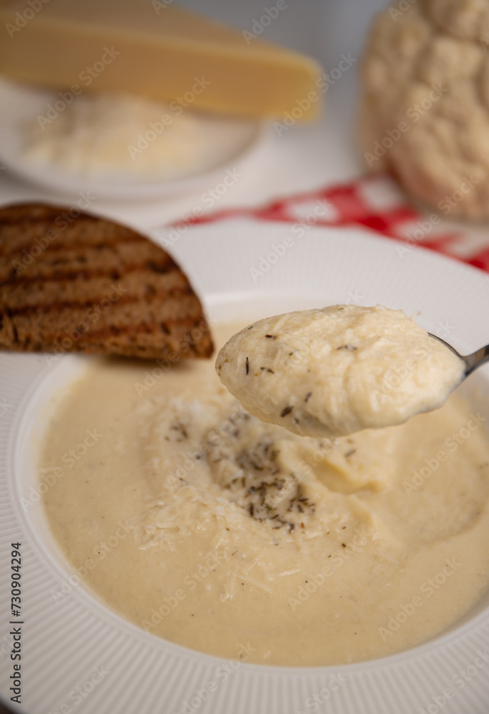 Cauliflower cream soup served in an elegant white plate with wide side, accompanied by a piece of grilled bread on the side. recipe for vegan vegetable soup Cauliflower cream soup served in an elegant white plate with wide side, accompanied by a piece of grilled bread on the side. recipe for vegan vegetable soup