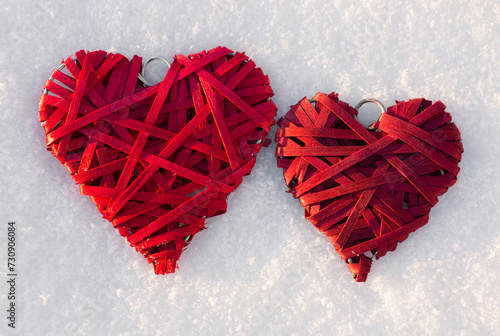 Happy valentines day background with two red hearts on white snow .