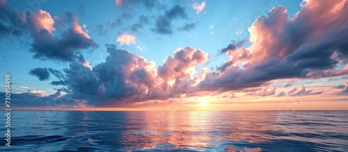 Scenic view of the Baltic Sea during sunset, with a captivating sky displaying glowing blue and pink clouds, soft golden sunlight, and the enchanting midnight sun.