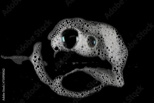 Soap foam, lather in shape scared faces isolated on black, with clipping path, texture and background 
