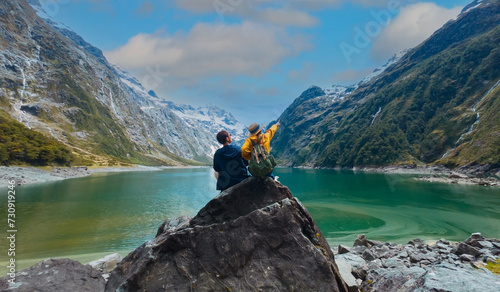  Travelers couple team look on the mountain landscape. Travel and active life concept  as Adventure travel in the mountains region in lake marian  fiordland national park © SASITHORN