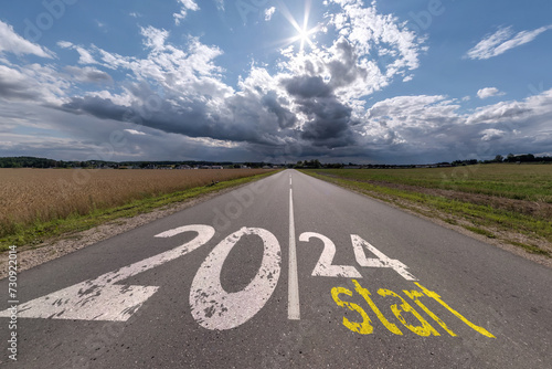 numbers 2023, 2024 and start on asphalt road highway with sunrise or sunset sky background. concept of destination in future, freedom, work start, run, planning, challenge, target, new year