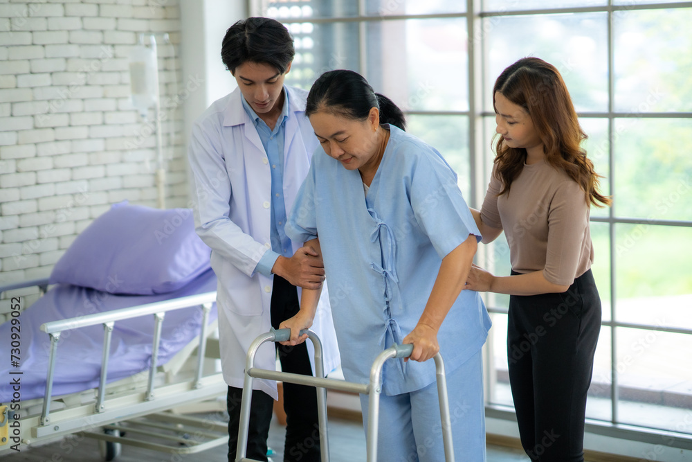 A physical therapist is helping a patient practice walking. By providing support for walking training The patient has pain in his ankle and broken leg. A physical therapist is helping a patient practice walking. By providing support for walking training The patient has pain in his ankle and broken leg.