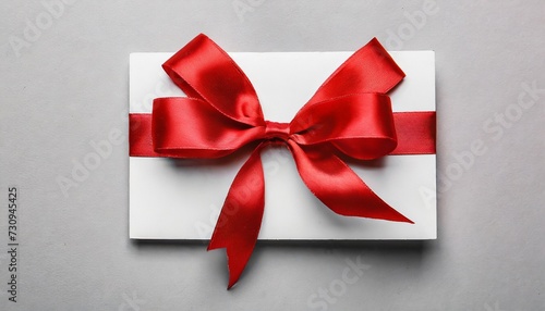 gift card with red ribbon bow on white background © Ashley