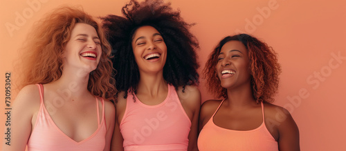 Three very happy girls wearing just beige underwear pose against background,
