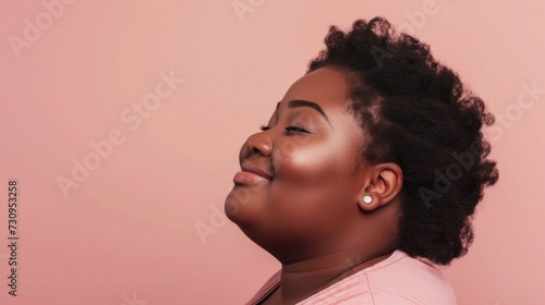 A person with a radiant smile closed eyes and a joyful expression set against a soft pink background with their head tilted back slightly showcasing a side profile view. photo