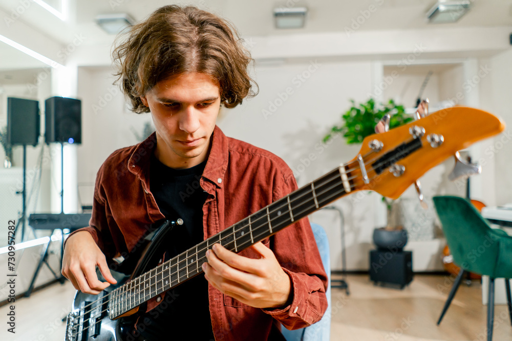 Obraz premium rock artist with long hair with electric guitar during rehearsal playing own track musical instrument string melodies