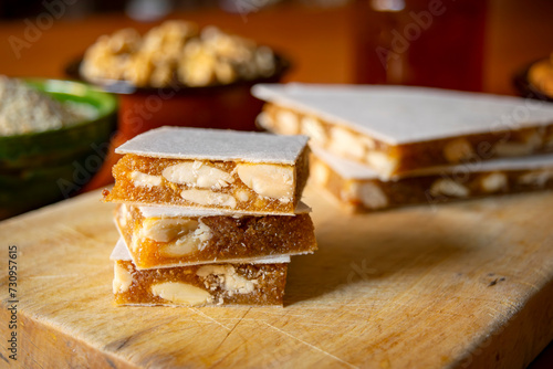 Close-up view of slices of Alajú on a wooden board, a variety of nougat traditional from the regions of Cuenca and Rincón de Ademuz in Spain photo