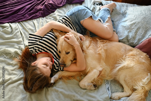 Cute Girl Playing With Golden Retriever Dog In Bed