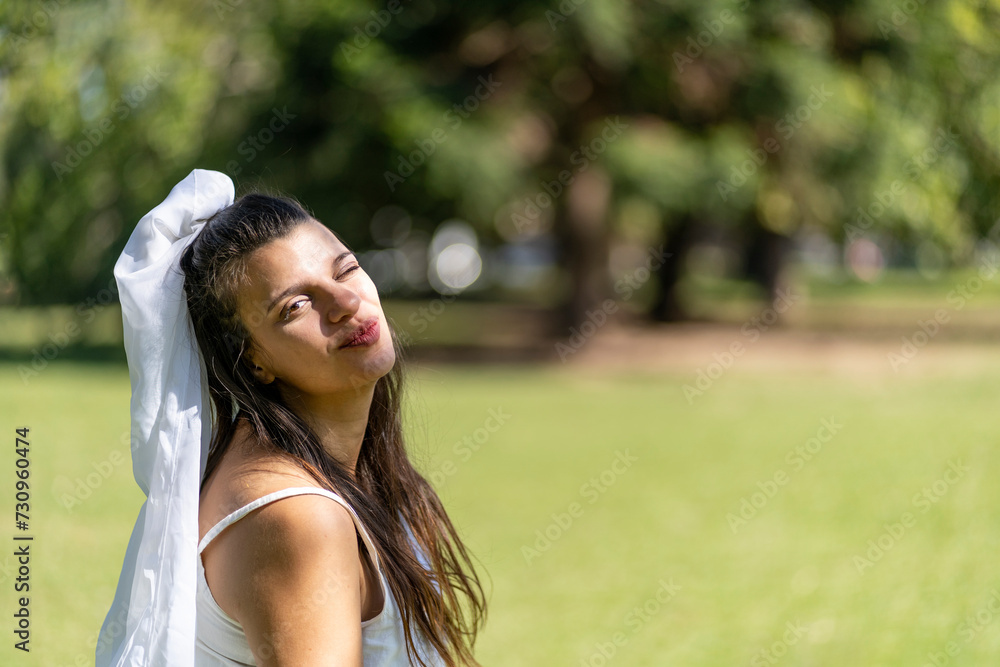 Latin bride in a white wedding dress in a park. Happy expression Latin bride in a white wedding dress in a park. Happy expression