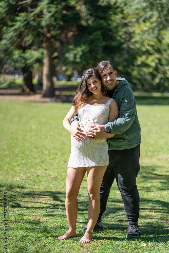 Pregnant woman posing with her partner outdoors Pregnant woman posing with her partner outdoors