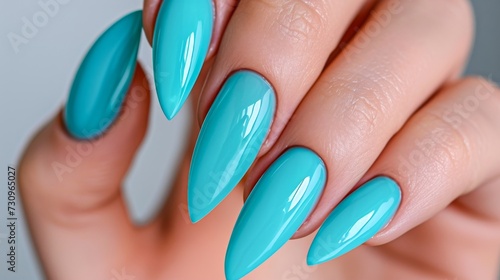 Vibrant turquoise enamel sparkles with glitter, enhancing the glossy finish of a perfectly manicured finger adorned with artificial nails and accented by a dazzling accessory of cosmetics