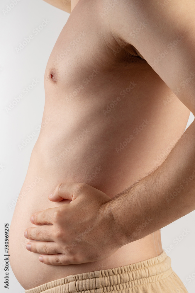 Man hold his growing belly Man hold his growing belly