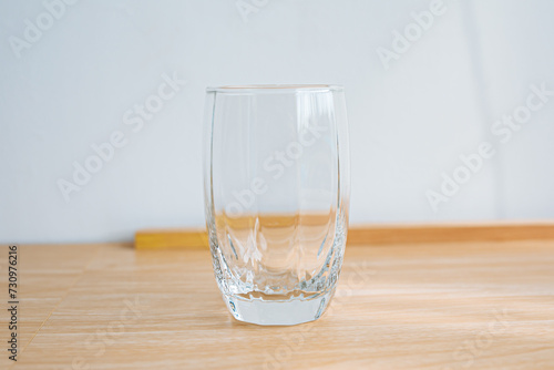 1 clear glass, wooden floor and white background.