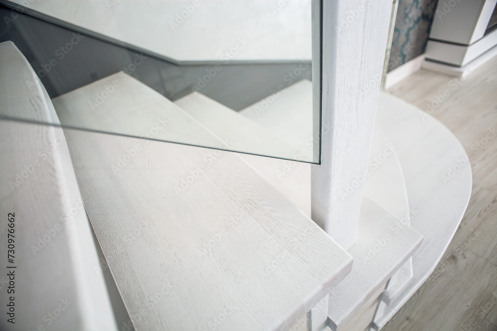 Fototapeta premium Luxurious modern interior design in a multi-storey building with an elegant white wooden staircase with details