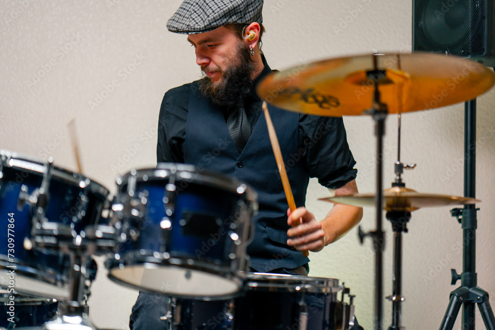 Obraz premium bearded male musician during rehearsal plays drums musical instrument drumsticks music concert