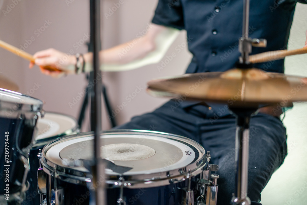 Fototapeta premium close-up musician during rehearsal plays drums musical instrument drumsticks music concert