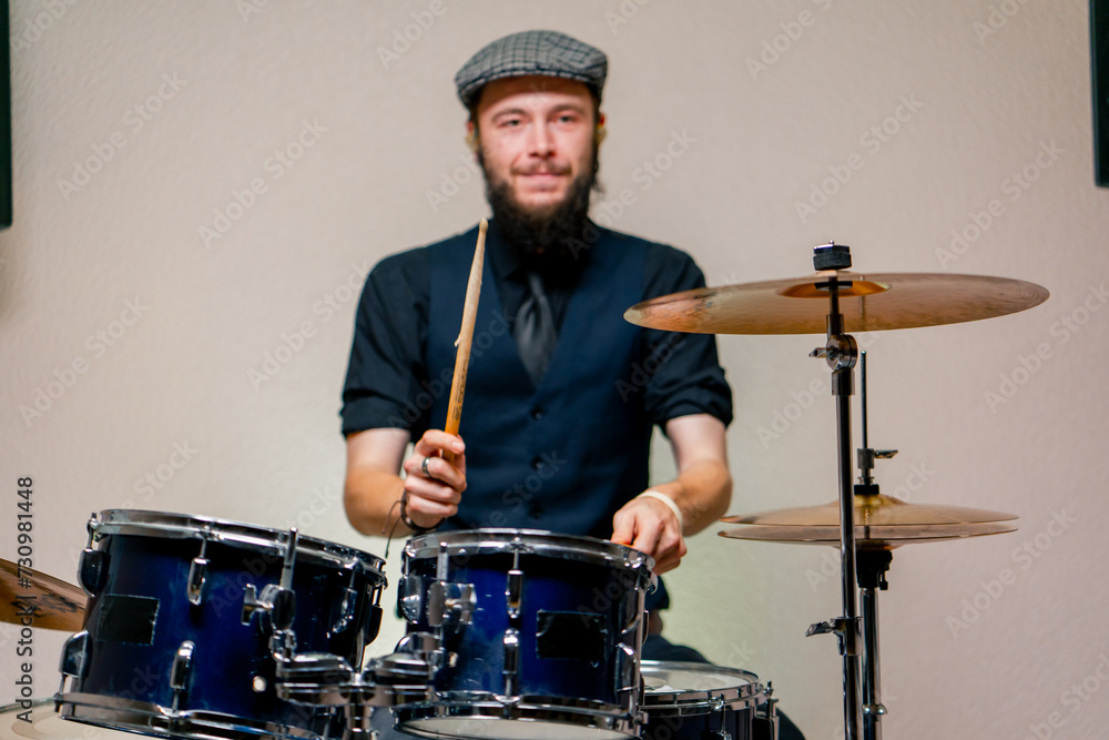 Obraz premium bearded male musician during rehearsal plays drums musical instrument drumsticks music concert