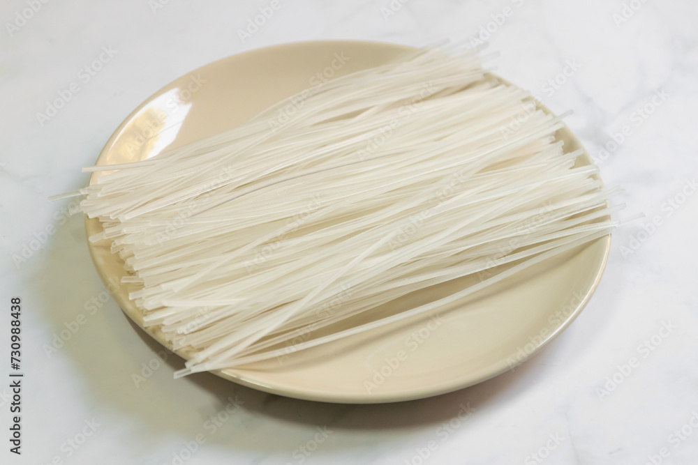 Dried uncooked rice noodles. Kuzukiri vermicelli is made from potato starch on dish. Dried uncooked rice noodles. Kuzukiri vermicelli is made from potato starch on dish.