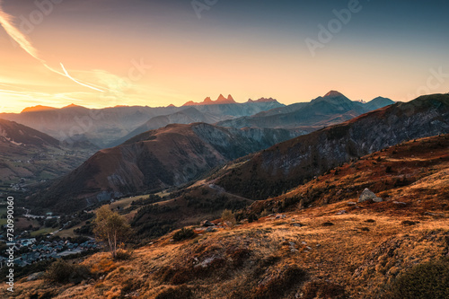 French Alps landscape of sunrise shining over Arves massif and ski town in valley during autumn at France