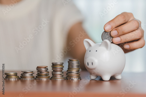 Hand saving money into a pi...