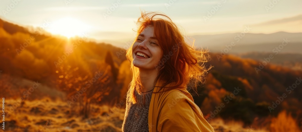 A happy woman with a smile stands on a grassy hill at sunset, enjoying the beautiful landscape of the ecoregion under the colorful sky. A happy woman with a smile stands on a grassy hill at sunset, enjoying the beautiful landscape of the ecoregion under the colorful sky.