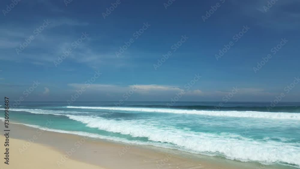 Drone flight over a sandy beach and undulating ocean on a sunny day. Drone flight over a sandy beach and undulating ocean on a sunny day.