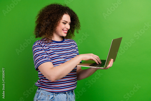 Profile photo of nice positive girl toothy smile hold use wireless laptop isolated on green color background