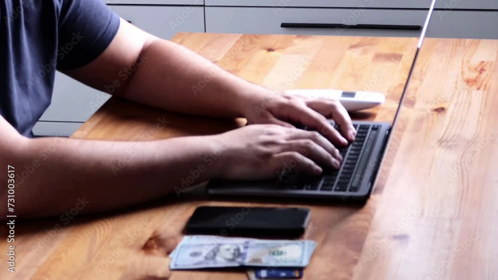 A person is seated at a desk with a laptop computer and a calculator. Their hand is holding the mouse, while their finger is pointing at the screen. A person is seated at a desk with a laptop computer and a calculator. Their hand is holding the mouse, while their finger is pointing at the screen.