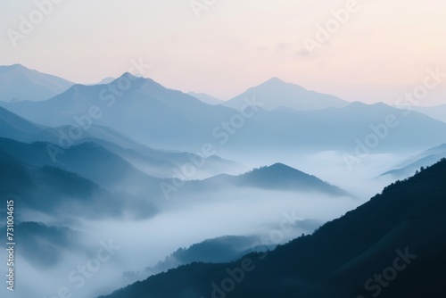 Misty mountain range, peaks emerging, at dawn's first light.