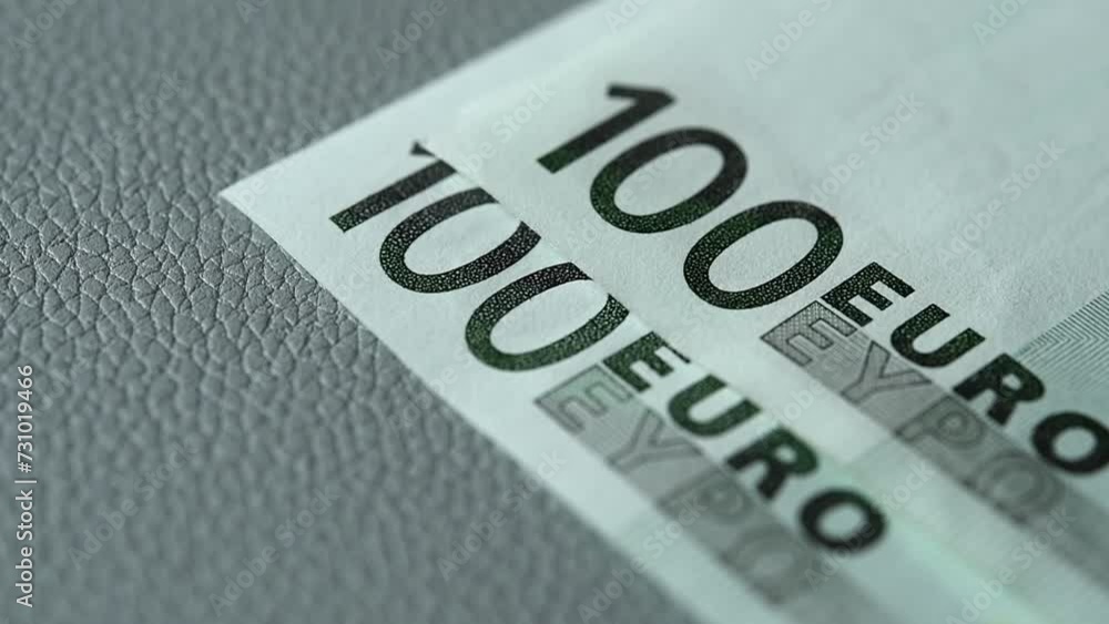 The denomination of one hundred euros. Counting cash in euros close-up on a gray background. The concept of savings accumulation. Currency exchange in euros. The denomination of one hundred euros. Counting cash in euros close-up on a gray background. The concept of savings accumulation. Currency exchange in euros.