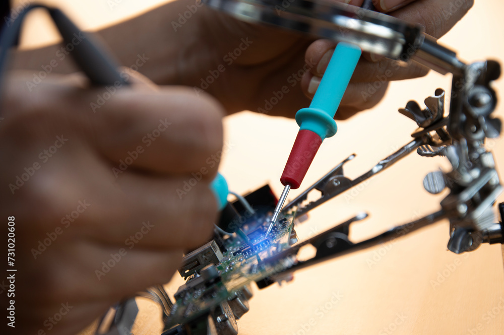 Technicians are repairing motherboards and checking electrical currents, repairing circuits Technicians are repairing motherboards and checking electrical currents, repairing circuits