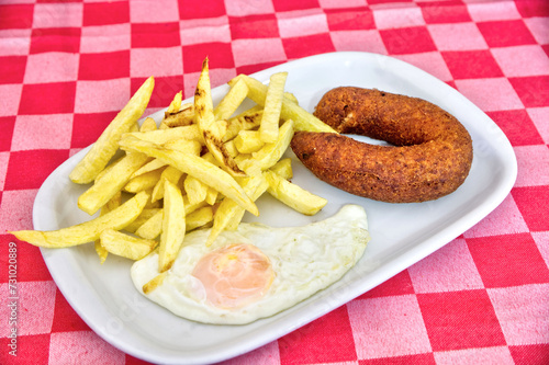 Fried "alheira" sausage, sunny-side-up egg, and golden fries. An irresistible Portuguese delicacy, perfect to showcase traditional cuisine.