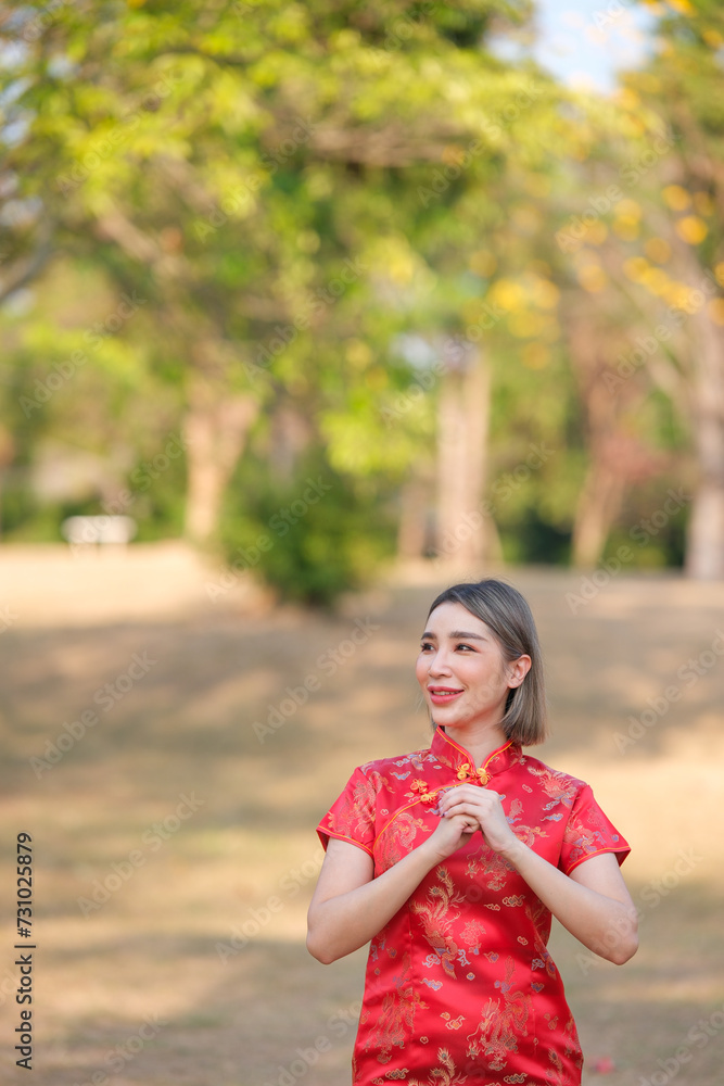 Asian woman in red cheongsam qipao dress holding lantern while visiting the Chinese Buddhist temple during lunar new year for traditional culture Asian woman in red cheongsam qipao dress holding lantern while visiting the Chinese Buddhist temple during lunar new year for traditional culture
