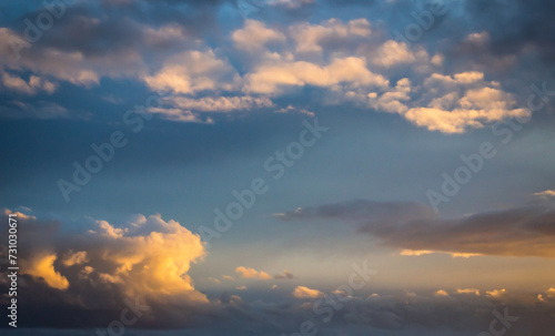 Blue sky clouds background. Beautiful landscape with clouds and orange sun on sky © Katerryna.R
