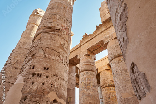 Different hieroglyphs on the walls and columns in the Karnak temple. Columns and blue sky in the great hypostyle hall at the karnak temple, Egypt photo