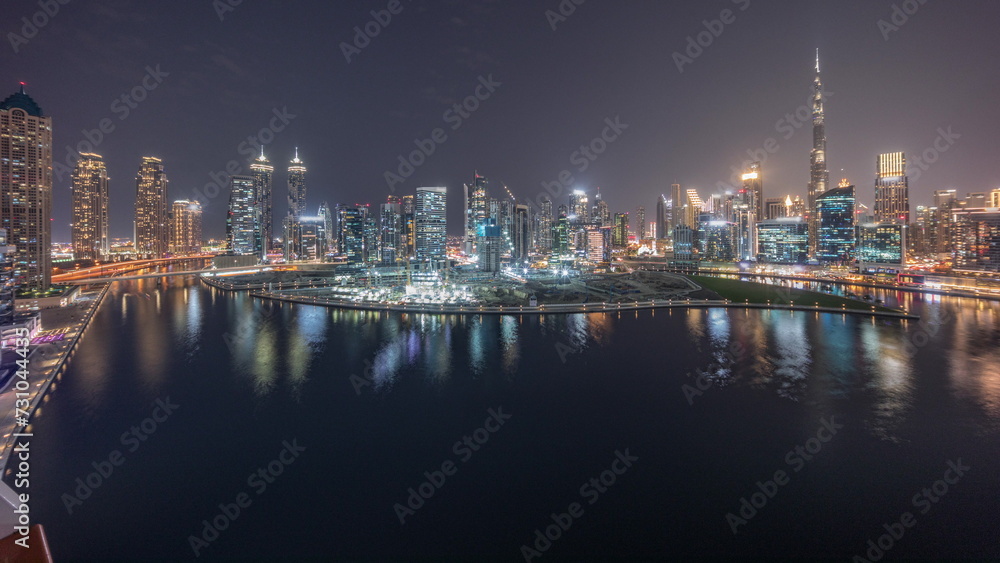 Aerial panorama of Dubai Business Bay and Downtown with the various skyscrapers and towers day to night timelapse