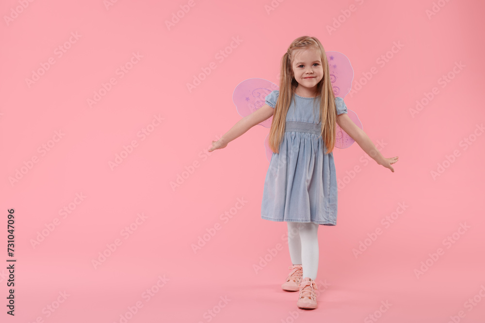 Cute little girl in fairy costume with violet wings on pink background, space for text Cute little girl in fairy costume with violet wings on pink background, space for text