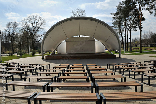 Konstfotografi Outdoor amphitheater in the park with benches and a stage.