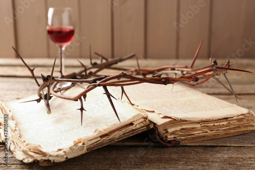 Crown of thorns, Bible and glass with wine on wooden table, selective focus
