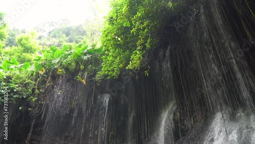 Goa Tetes waterfall. Many streams flow over the stones against the backdrop of beautiful nature. Lumajang Province, East Java, Indonesia photo